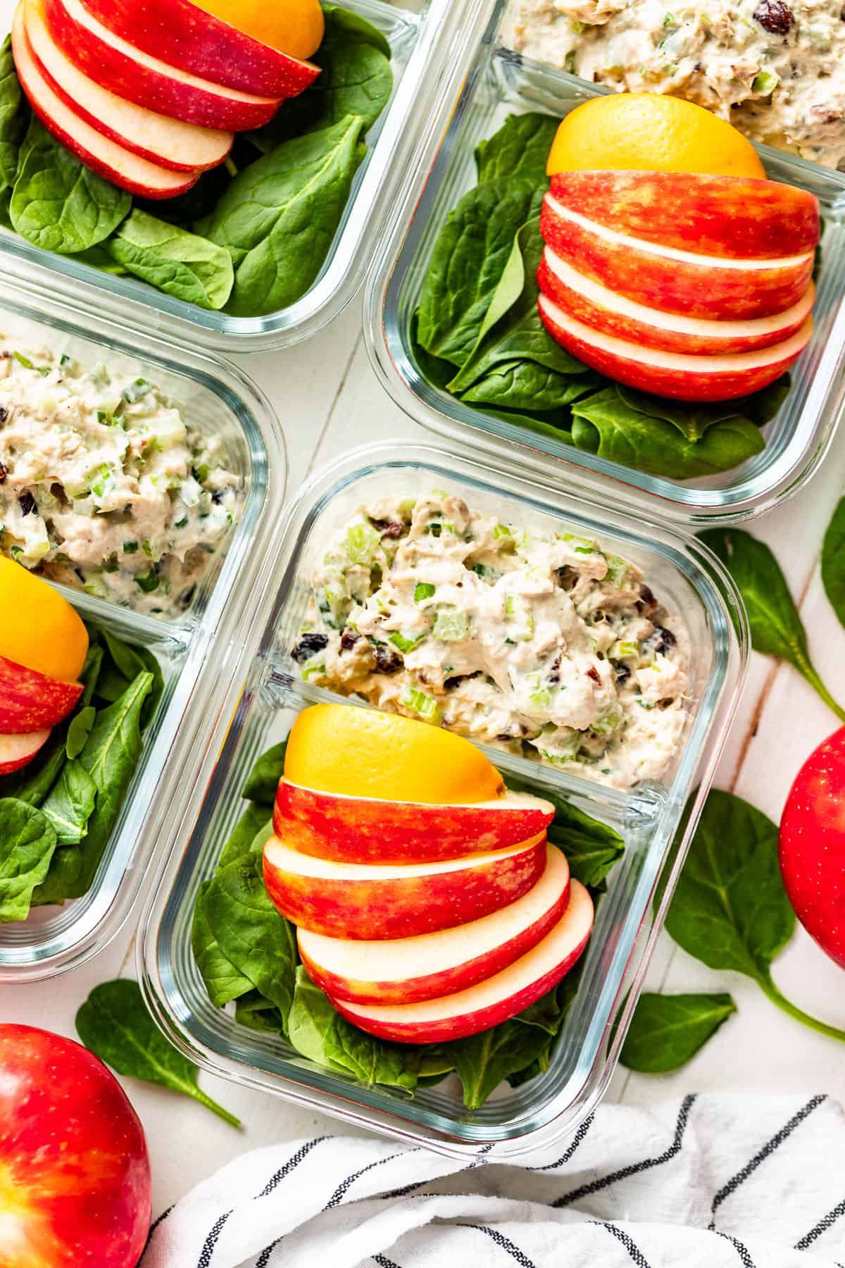 Straight down view of Healthy Tuna Salad in meal prep glass containers placed on an angle with apples on the side.