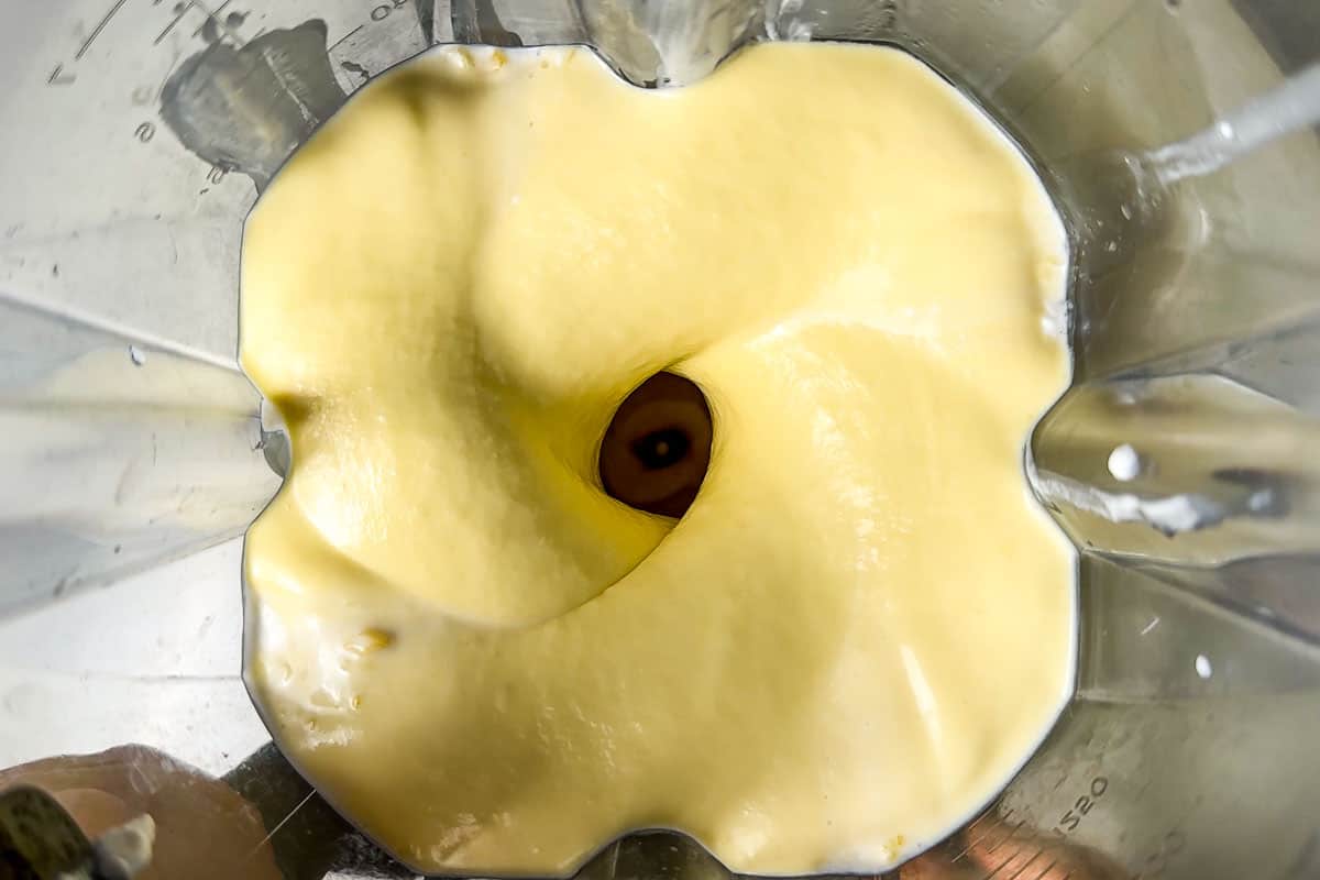 Blending the coconut milk and mango in a blender container.