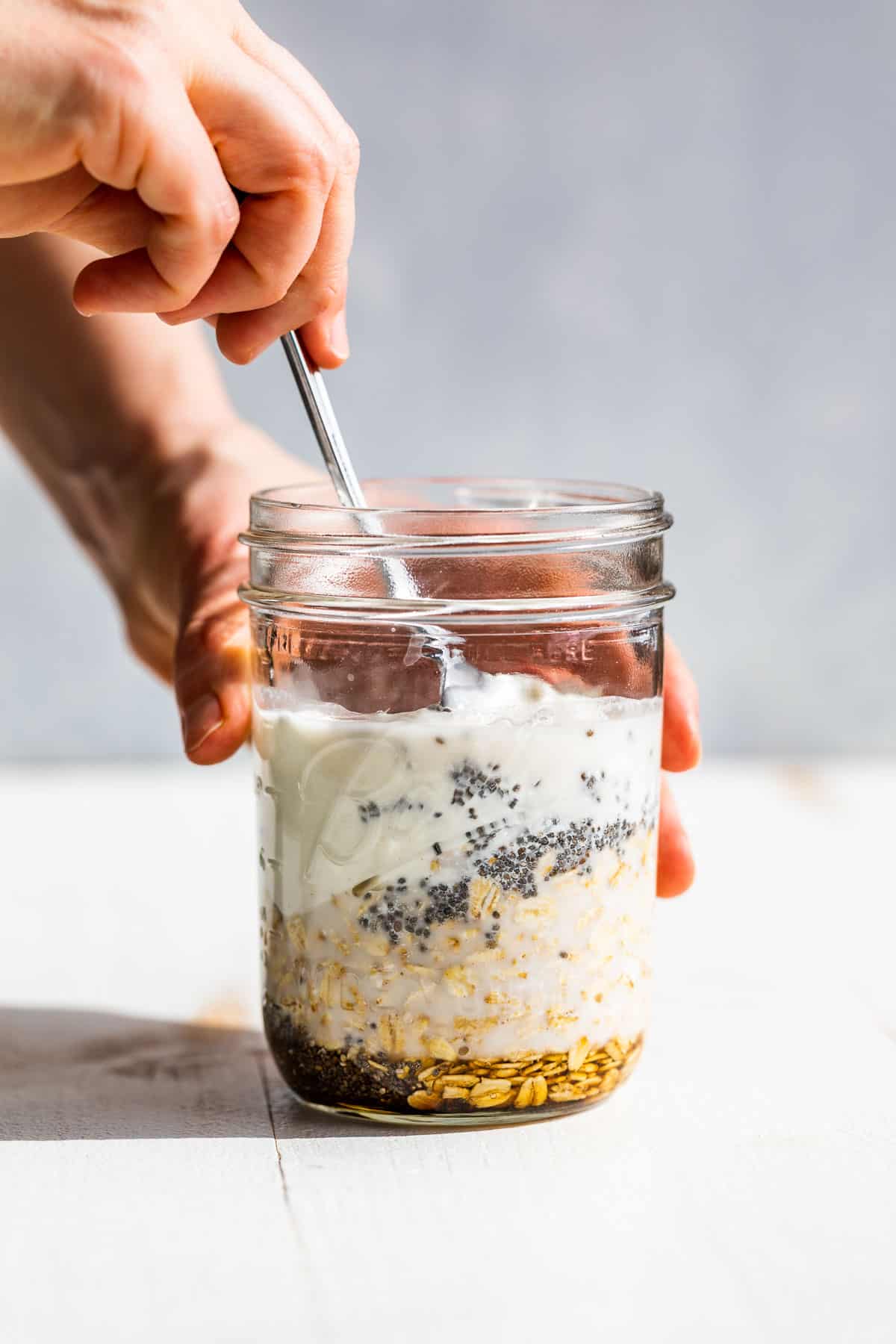 Stirring together all the ingredients for the overnight oats in a mason jar.