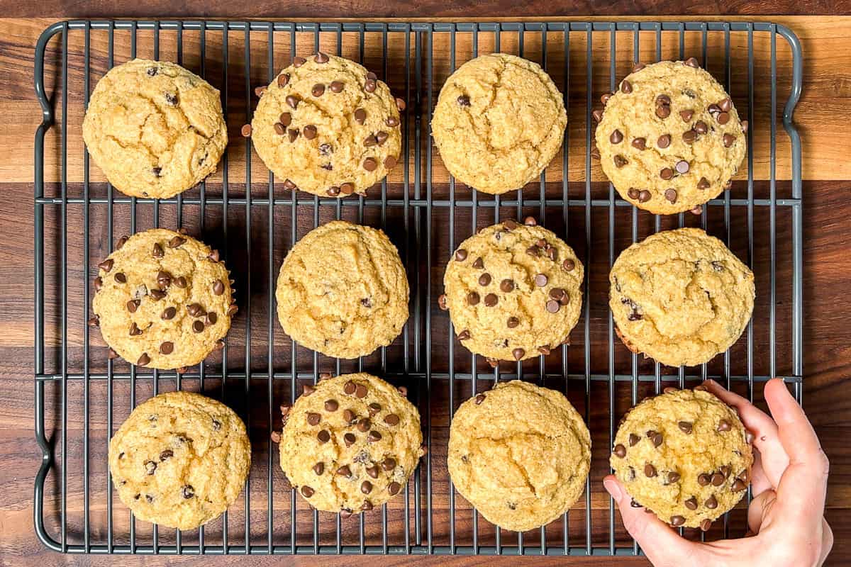 Baked Paleo Banana Muffins being placed on a wire cooling rack.