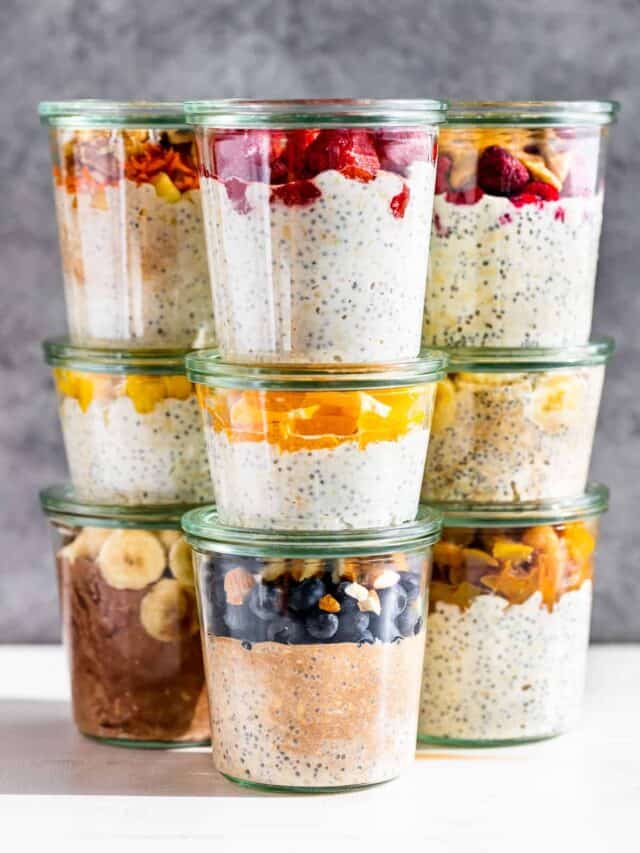 Clear glass jars filled with nine different flavors of overnight oats.