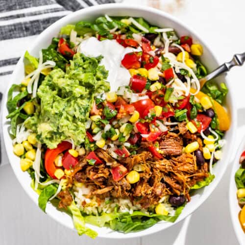 Straight down view of 2 Carnitas Burrito Bowls with a fork in one.