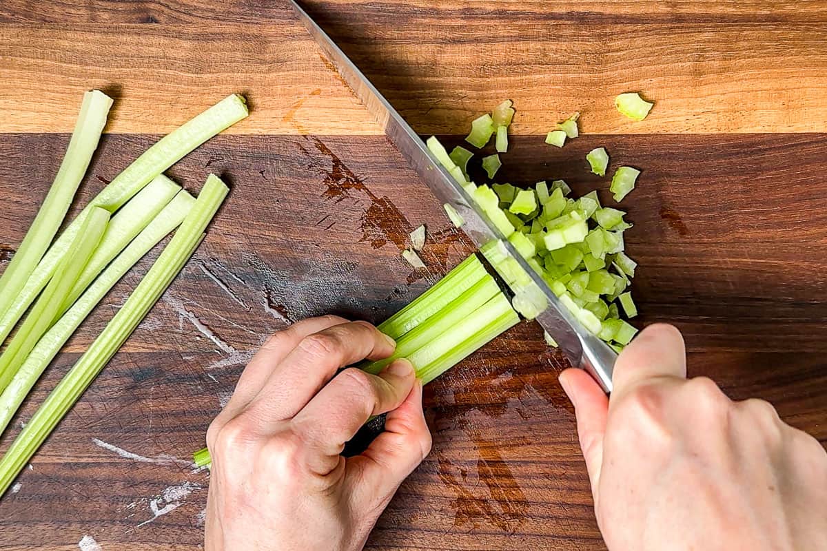 Dicing up the celery on a wood cutting board.