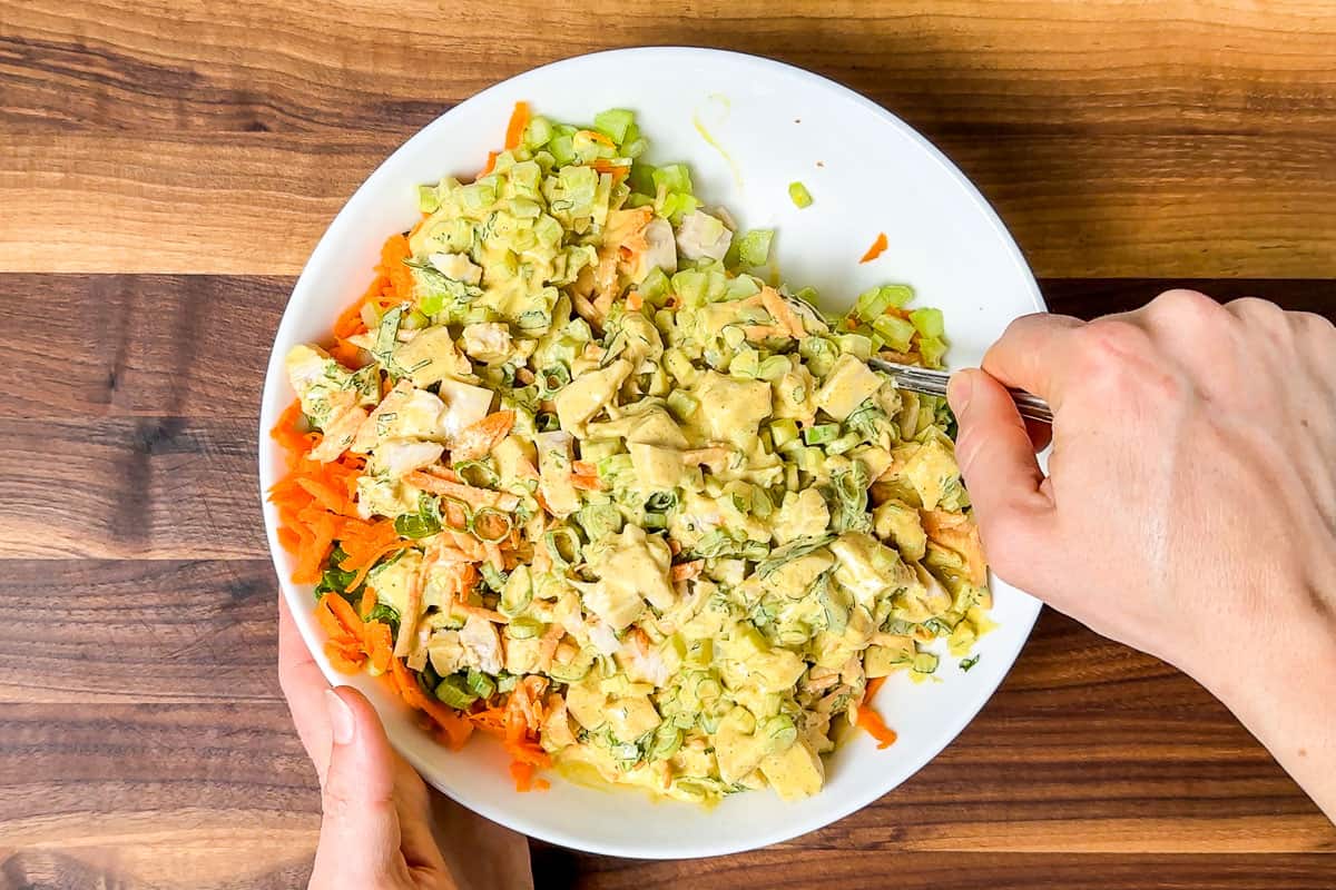 Mixing the curry dressing into the chicken salad.