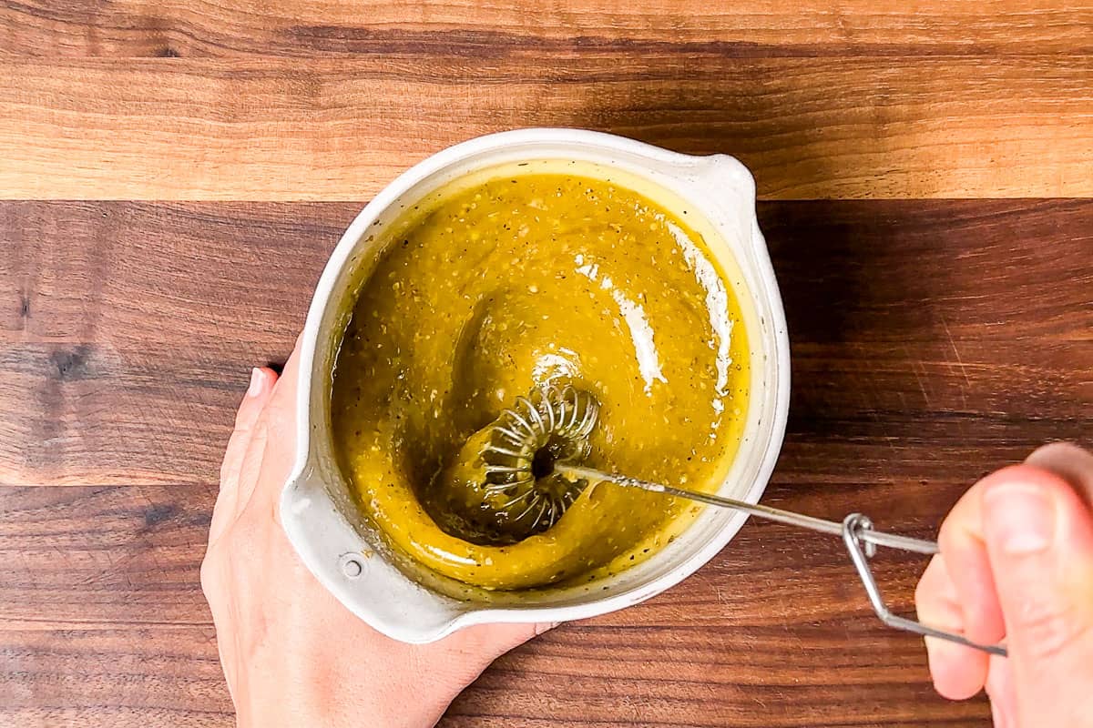 Whisking together the dressing for the Italian Chopped Salad in a pottery bowl.