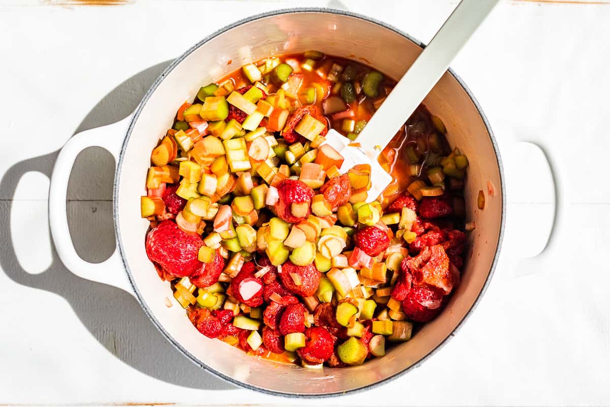 Rhubarb and strawberries mixed together in a white cooking pan.