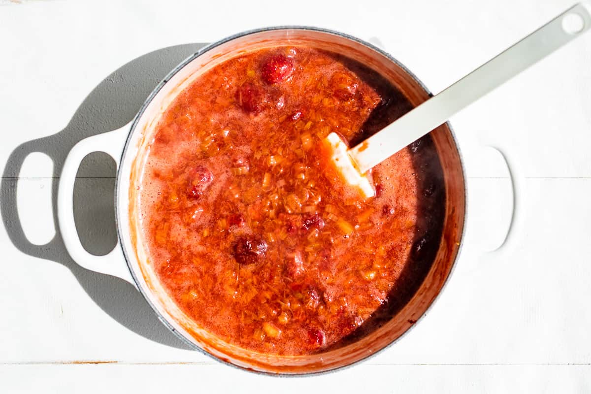 Finished strawberry rhubarb sauce in a white cooking pan.