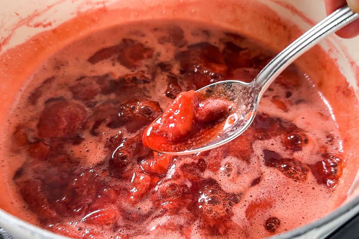 A spoon showing the consistency of the finished Strawberry Compote.