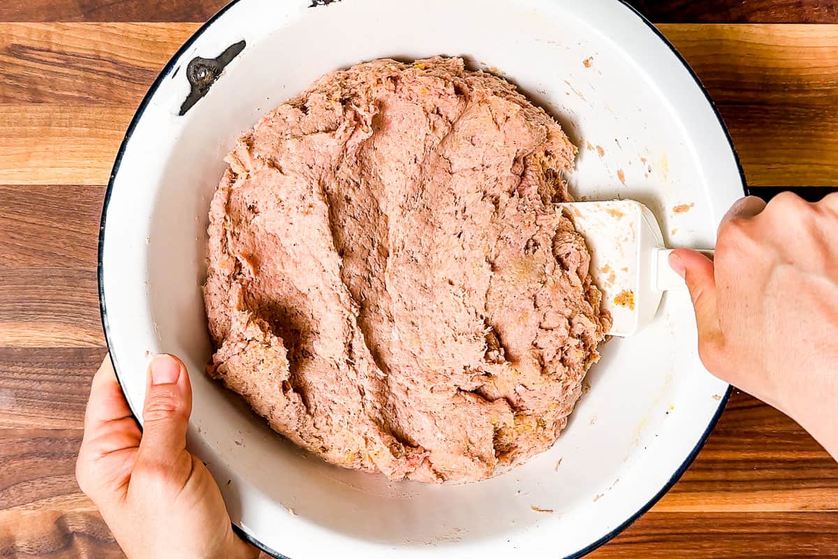 Mixing together the ground turkey meatballs mixture with a spatula.