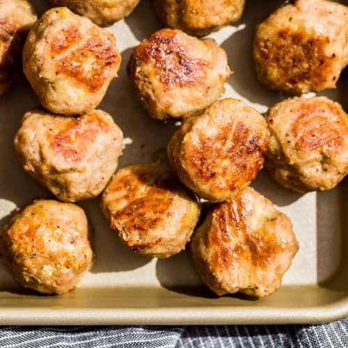 Straight down view of one quarter of a gold baking sheet filled with Baked Turkey Meatballs.