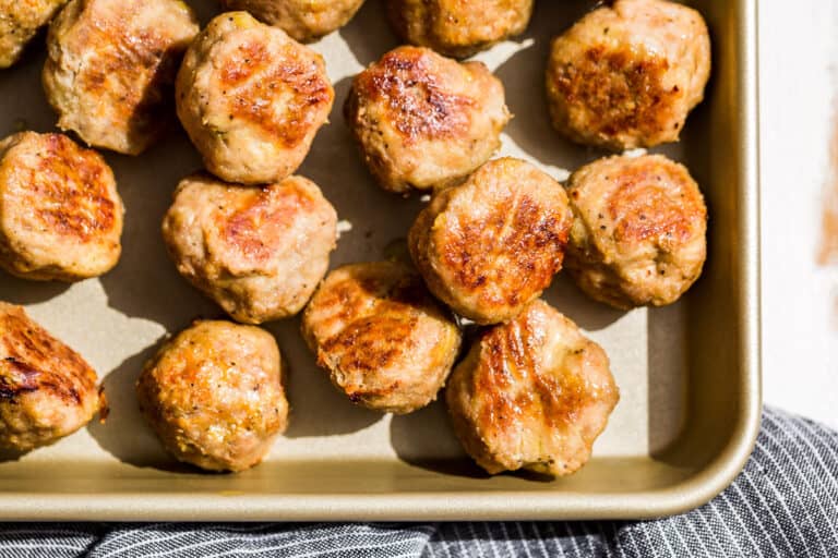 Straight down view of one quarter of a gold baking sheet filled with Baked Turkey Meatballs.
