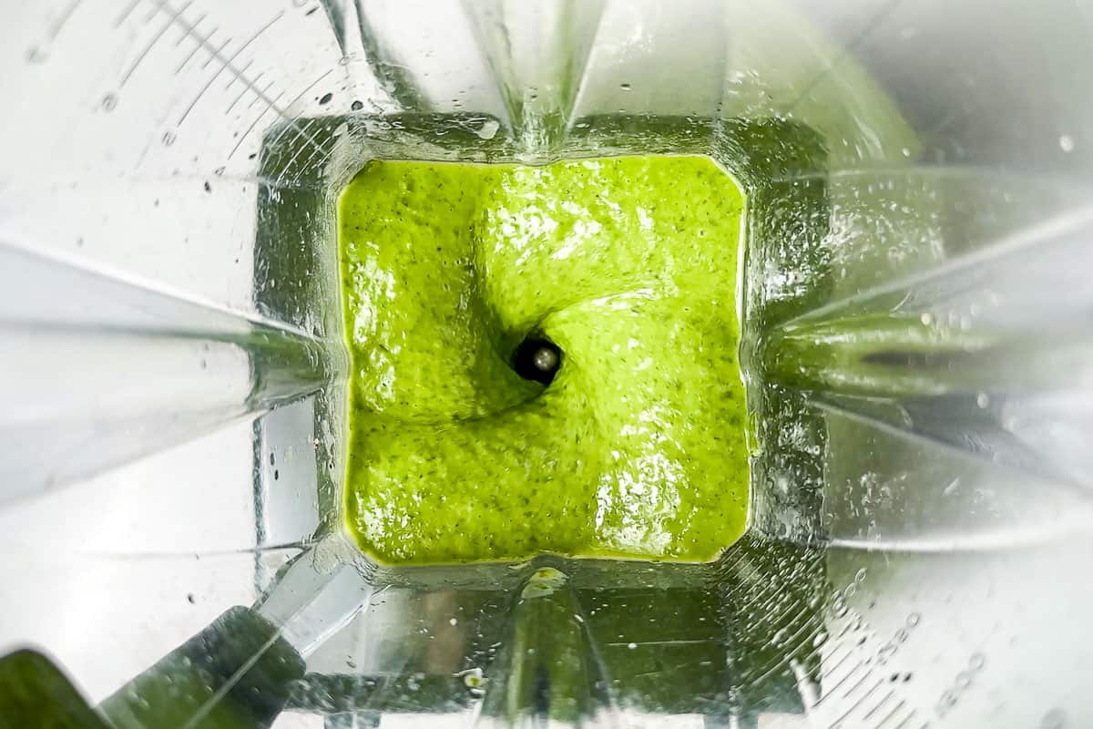 Blending the basil vinaigrette in a blender container.