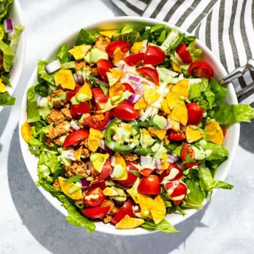 Straight down view of two bowls of turkey taco salad on a blue background.