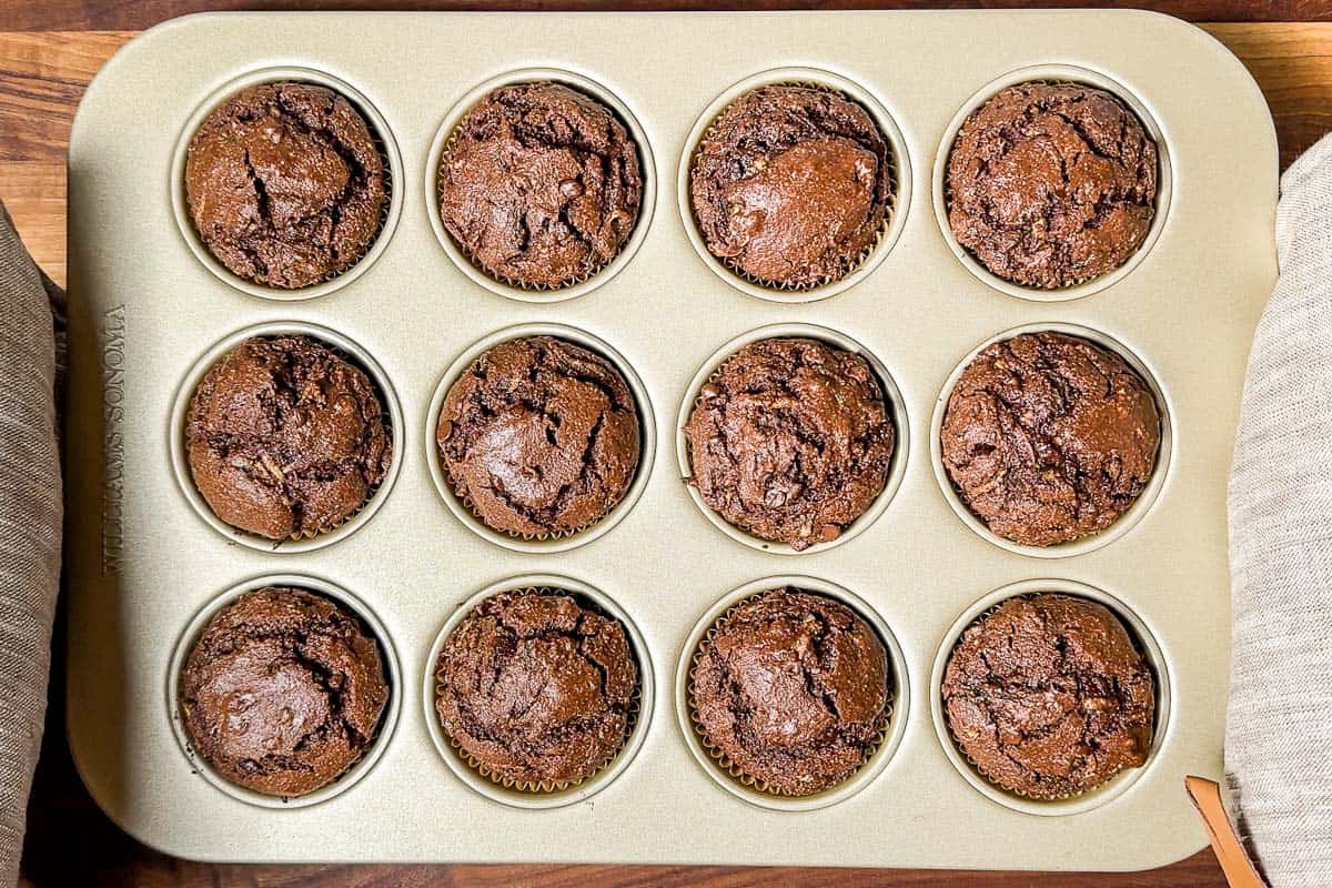 Freshly baked healthy chocolate zucchini muffins still in the muffin tin.