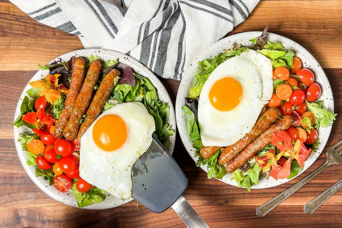 Topping the breakfast salads with over easy eggs.
