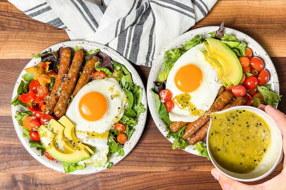 Drizzling the breakfast salads with everything bagel dressing.