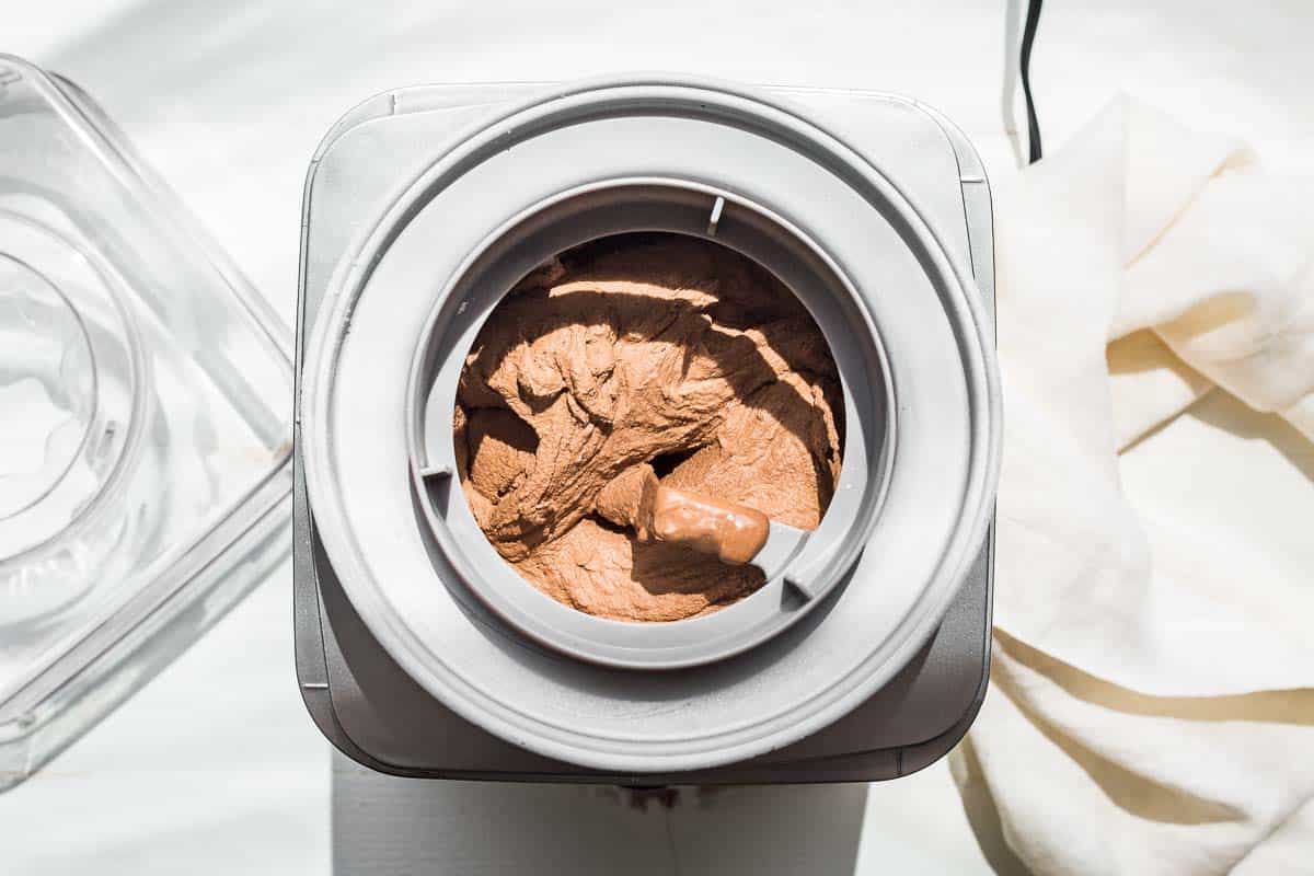 Chocolate avocado ice cream freezing in an ice cream maker.