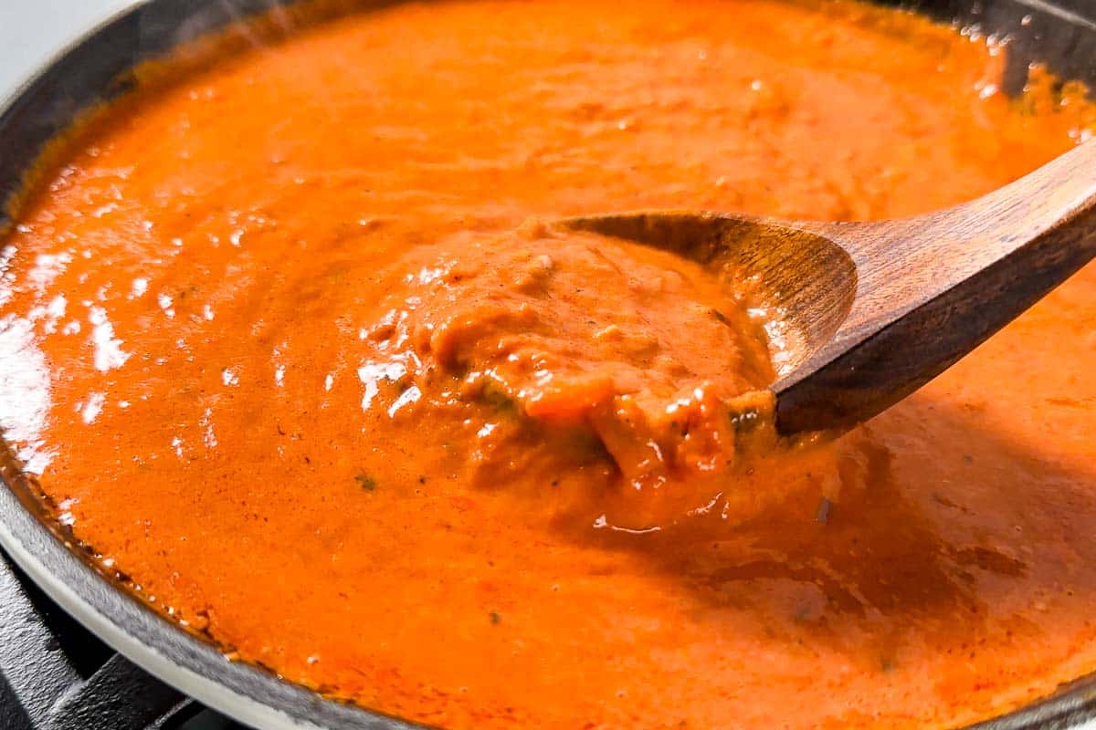 Side view of the reduced creamy tomato sauce in a skillet.