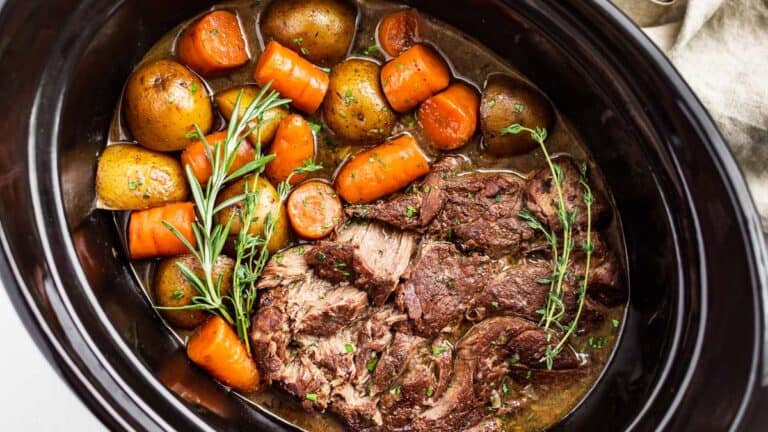 Slow cooker pot roast in a slow cooker bowl.