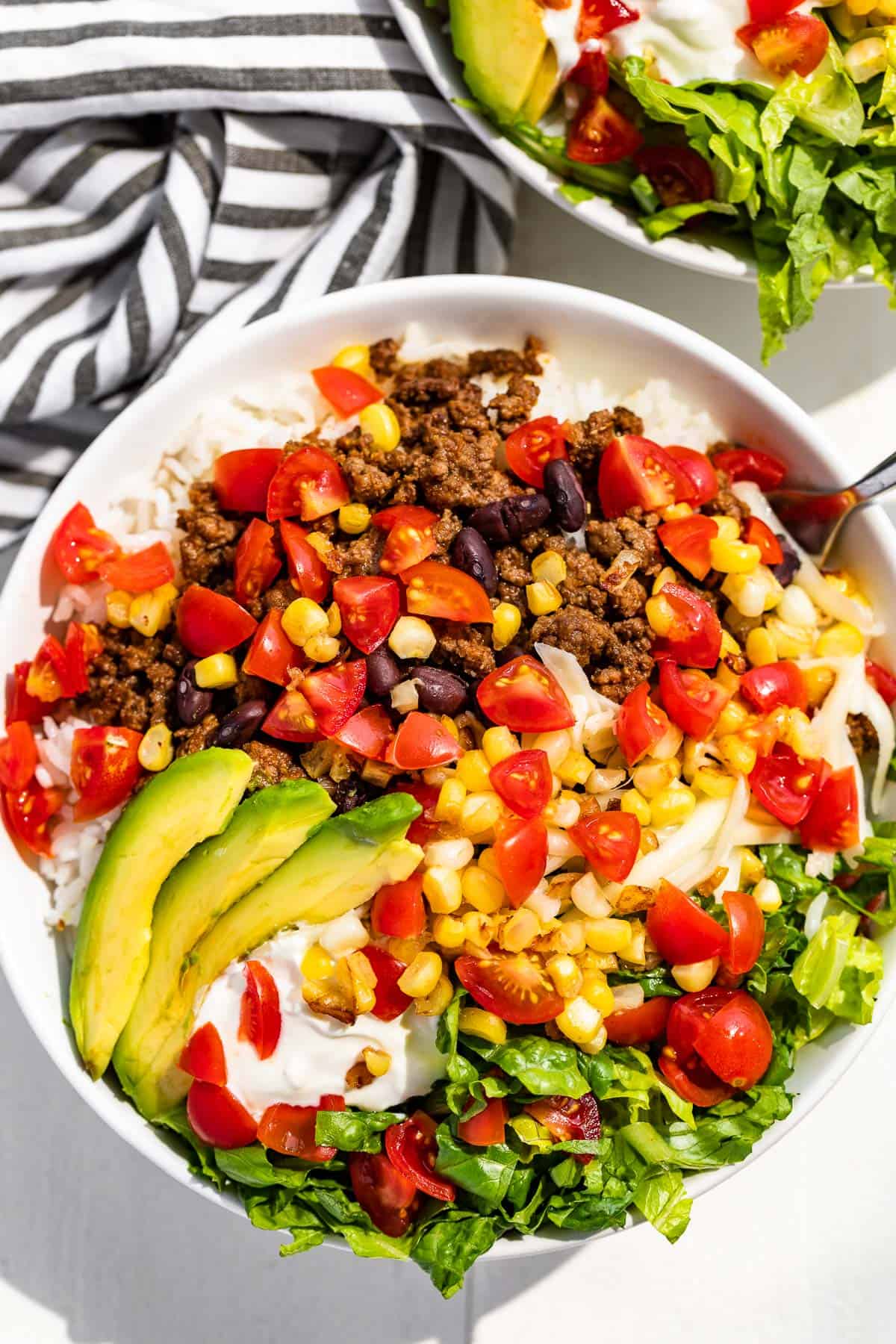 Straight down view of Taco Bowls with a striped linen in the background.