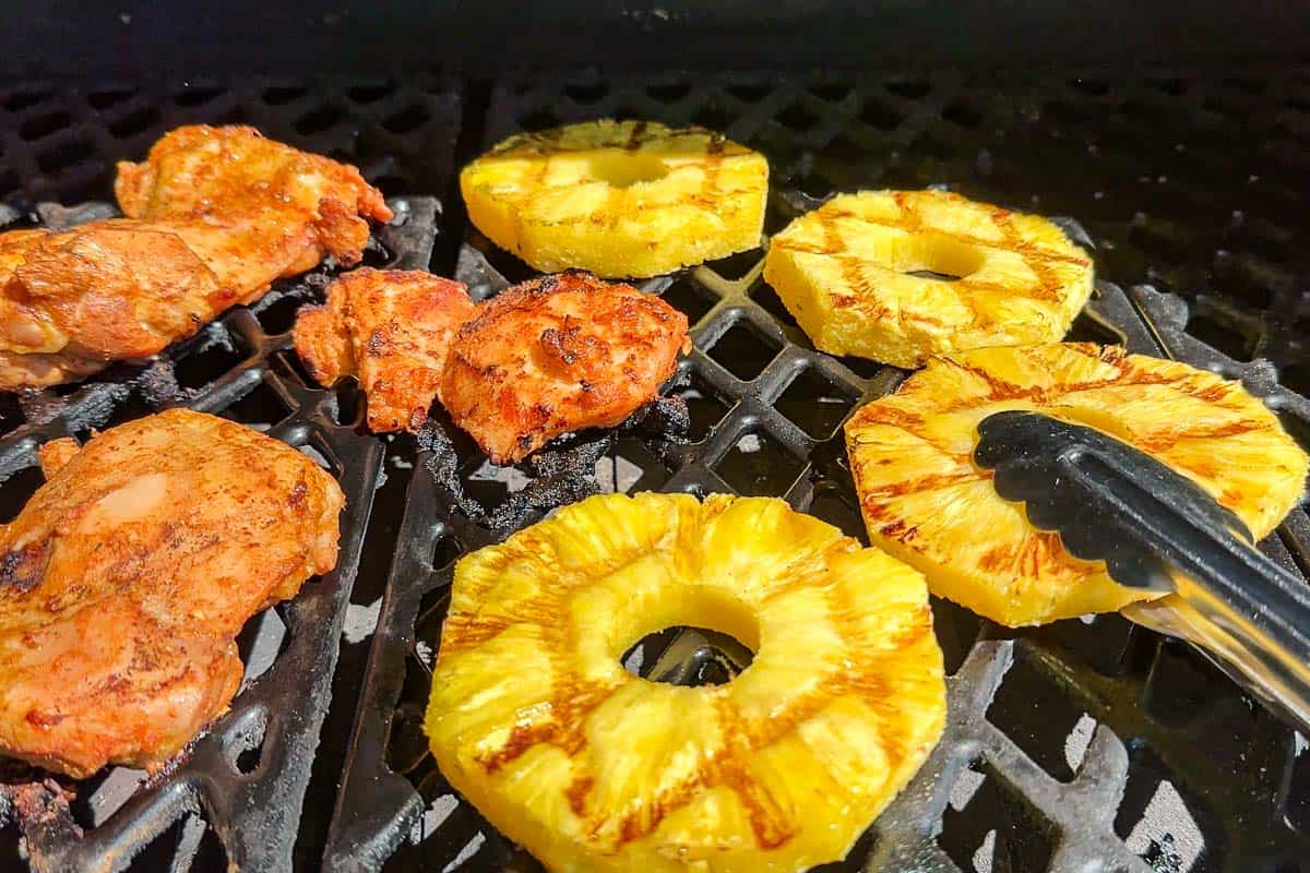Grilling the red curry marinated chicken and sliced pineapple.