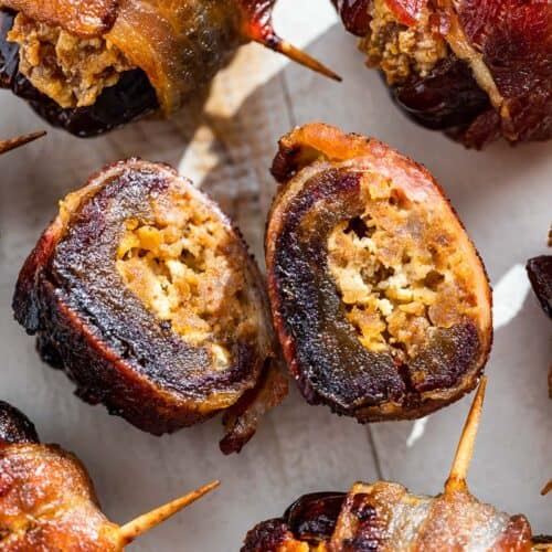 Baked bacon wrapped dates with one cut in half to see the cream cheese chorizo filling.
