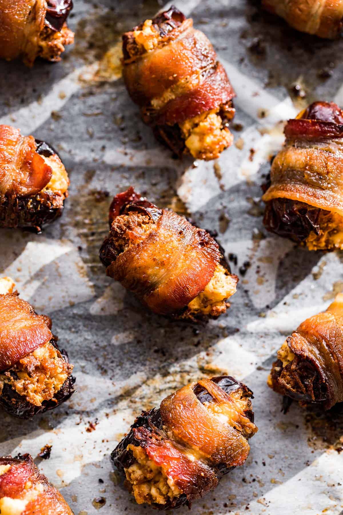 Bacon Wrapped Dates baked and crispy on parchment paper.