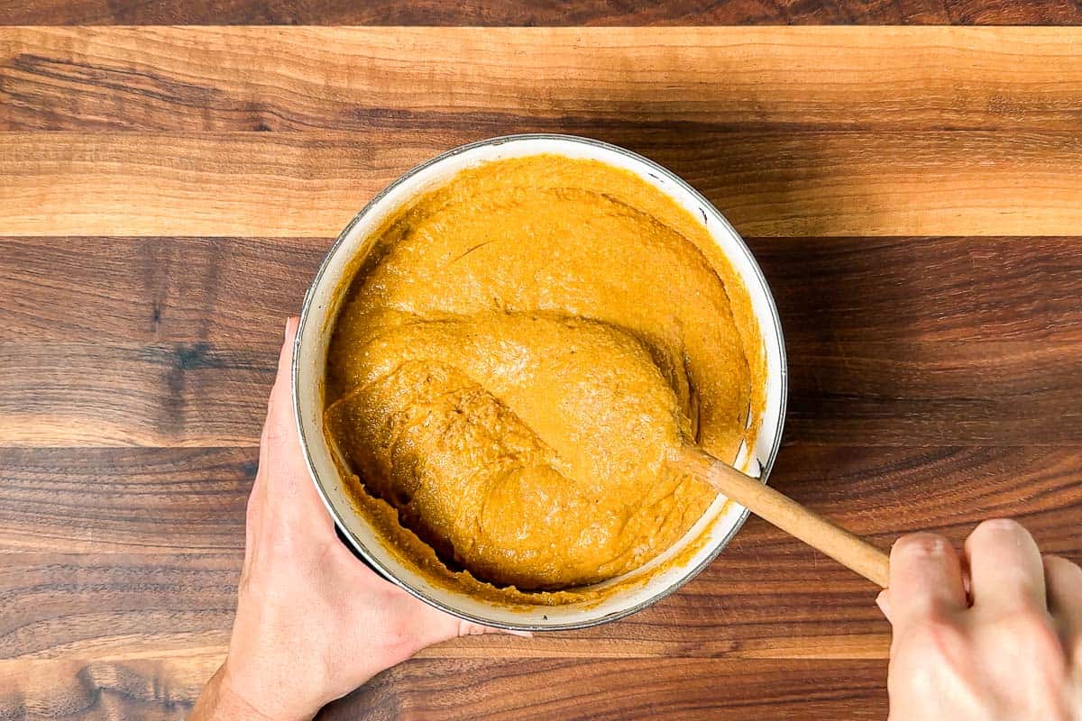 Mixing the wet ingredients into the flour mixture into a smooth pumpkin bread batter.