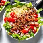 Finished burger bowls with a pottery container full of secret sauce dressing on the side of the bowl.