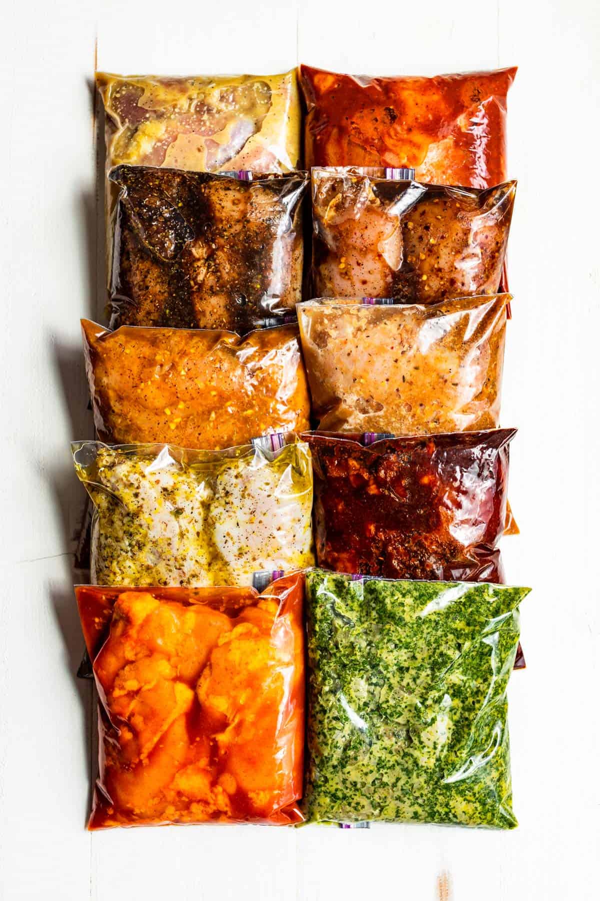 All ten chicken marinades in Ziplock bags arranged in two rows in a white background.