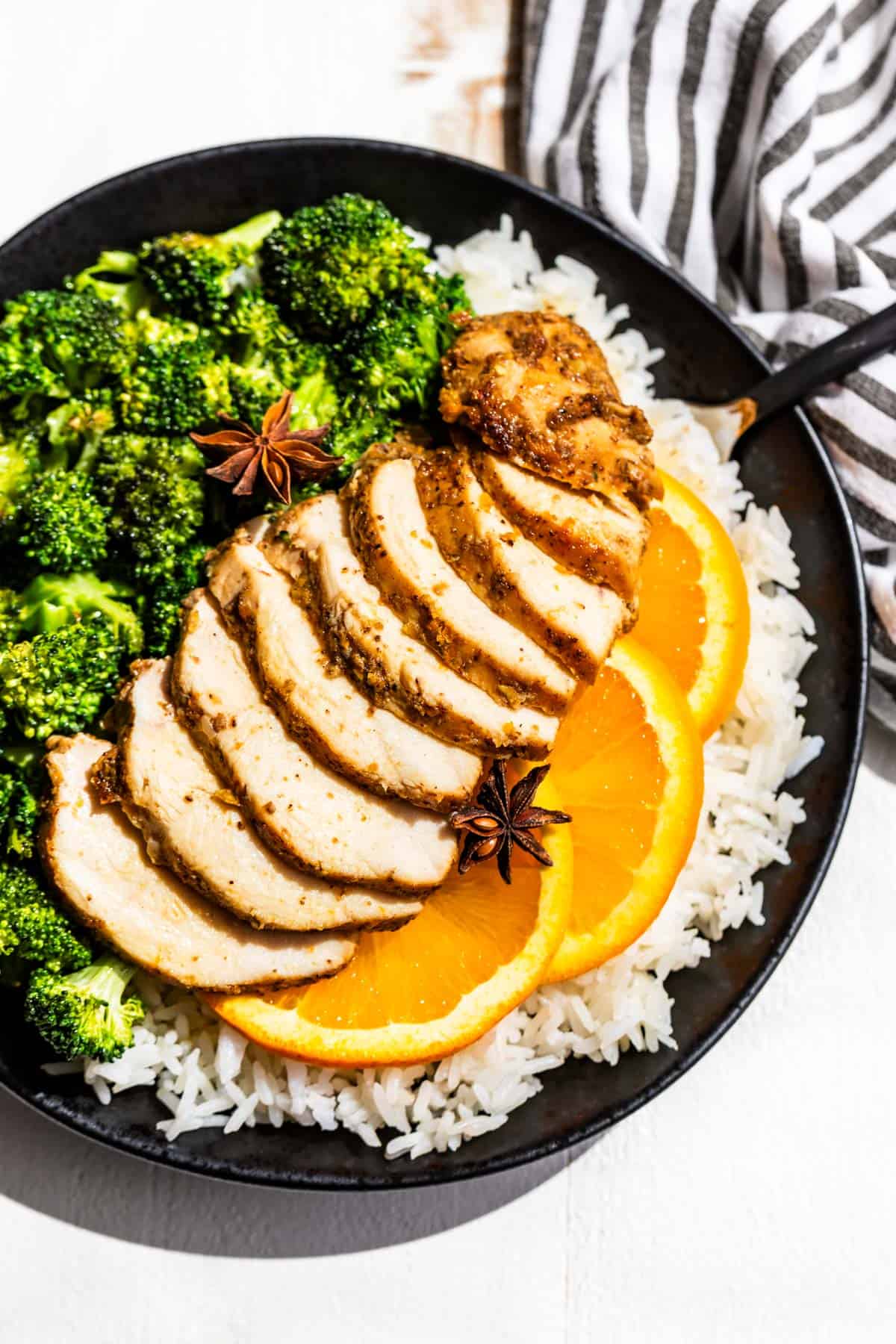 The Orange 5-Spice Marinaded Chicken cooked, sliced and placed over the top of rice with roasted broccoli on the side.