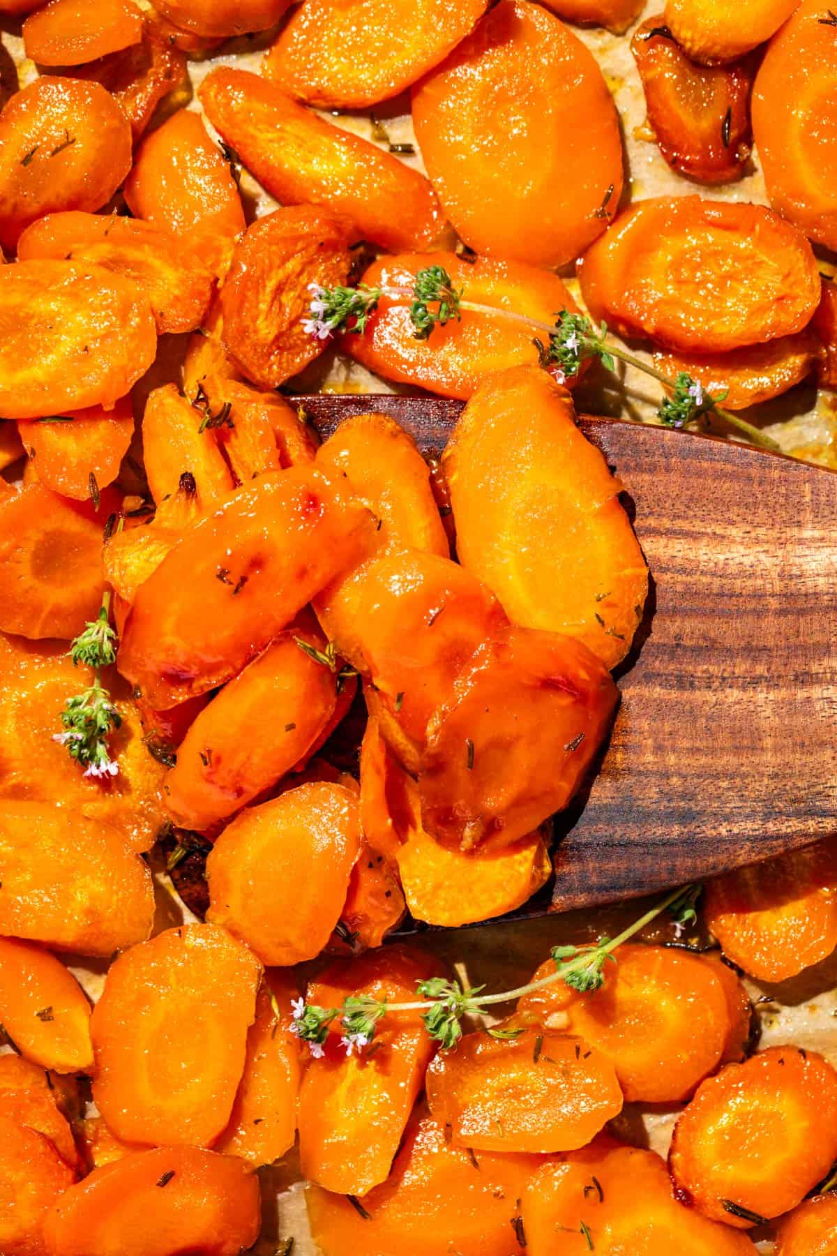 Close up of honey glazed carrots on a wood spatula.