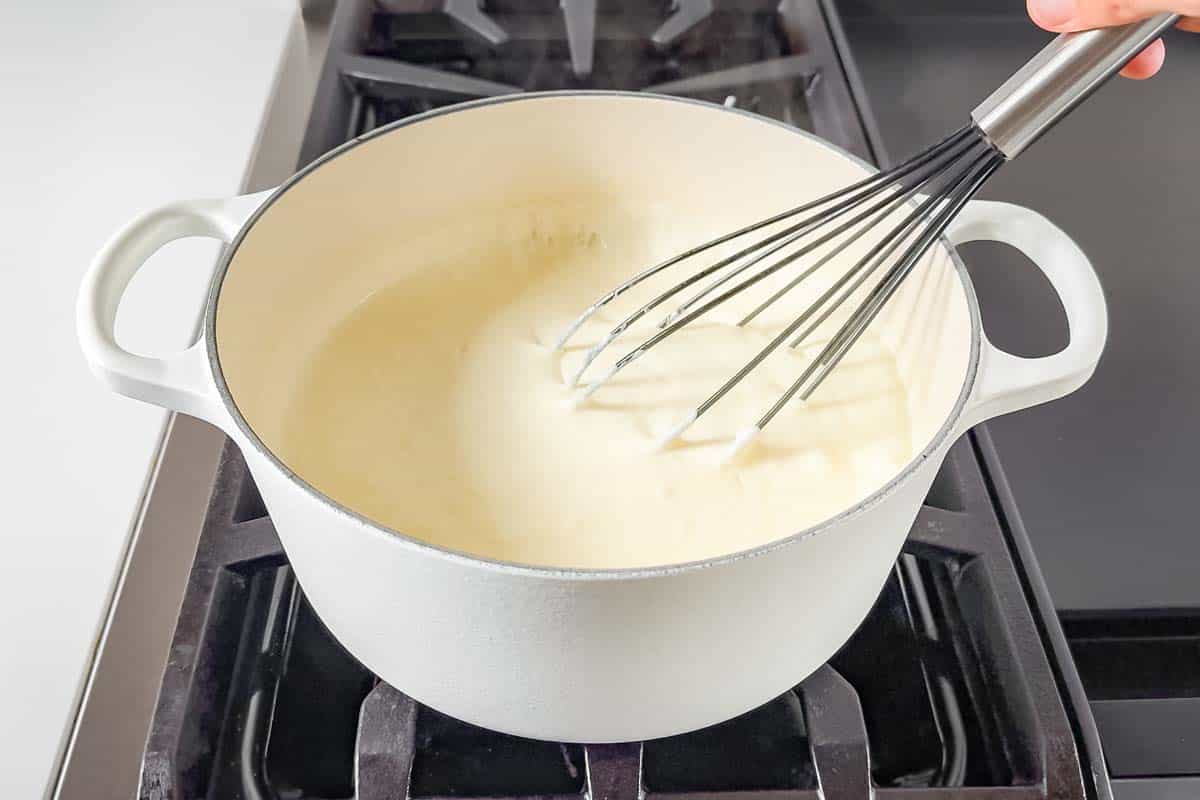 Whisking in the half and half to the butter flour roux mixture.
