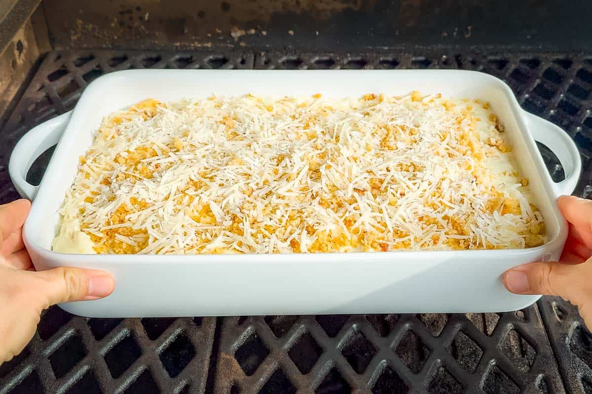 Placing the mac and cheese into the smoker.