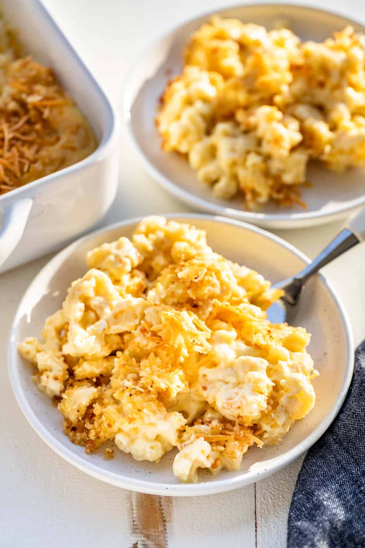 Two plates of Smoked Mac and Cheese with the baking dish on the side.