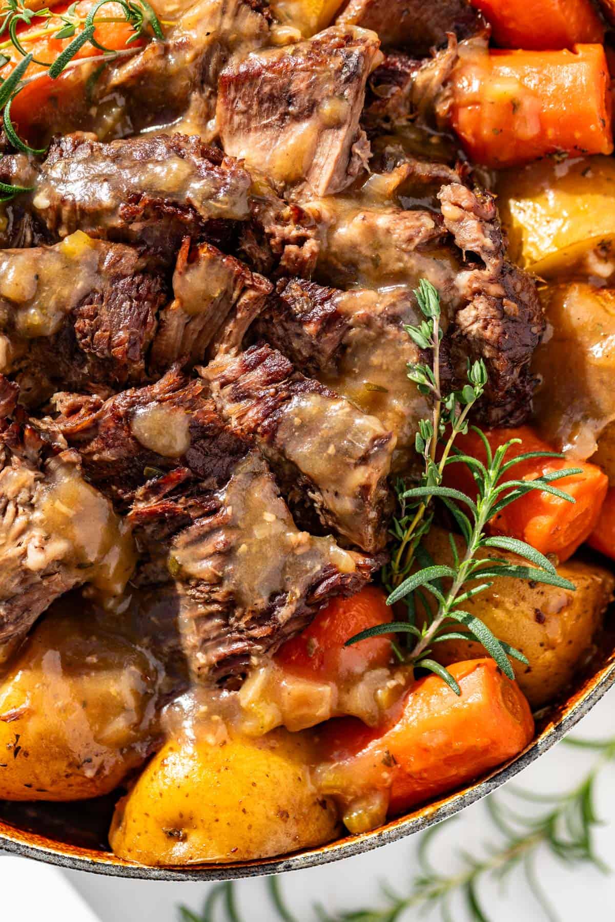 Close view of sliced pot roast, potatoes, and carrots.
