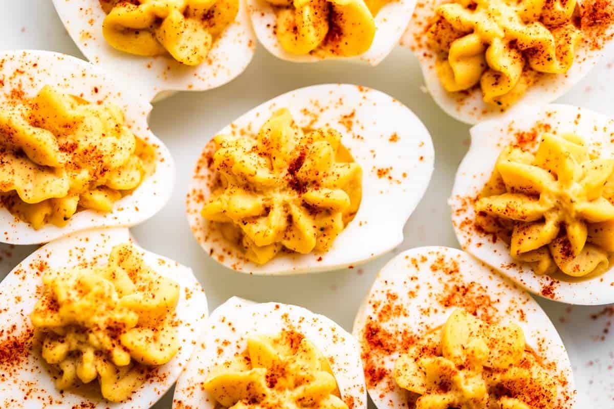 Deviled eggs sprinkled with paprika on a plate.