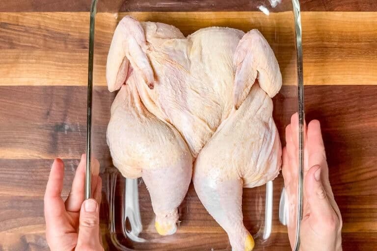 Placing the dry brined chicken into a shallow baking dish.