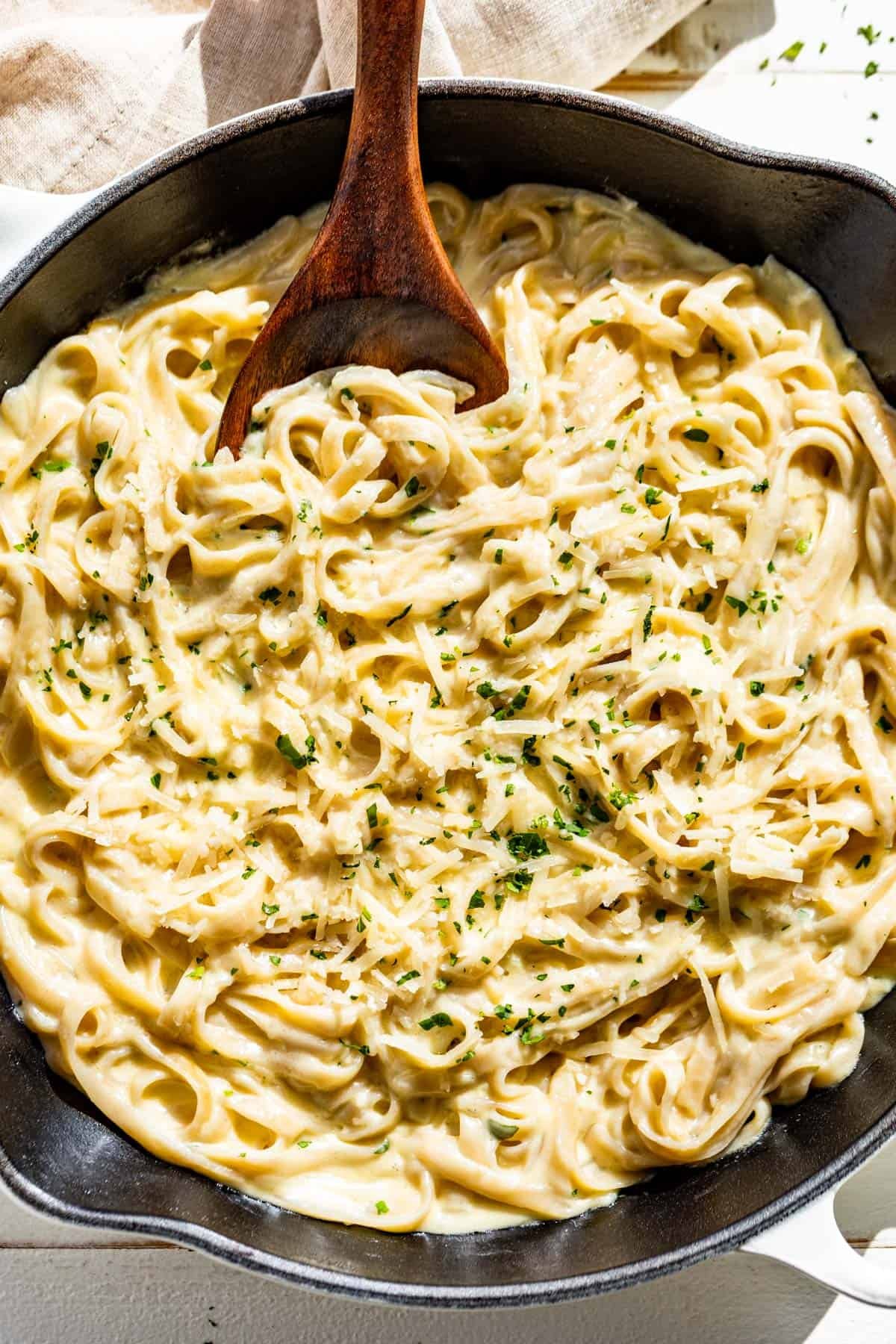 Creamy parmesan linguine pasta in a large white skillet.