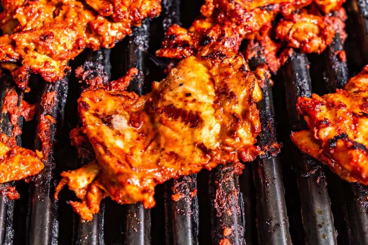Marinated chicken thighs on the grill.