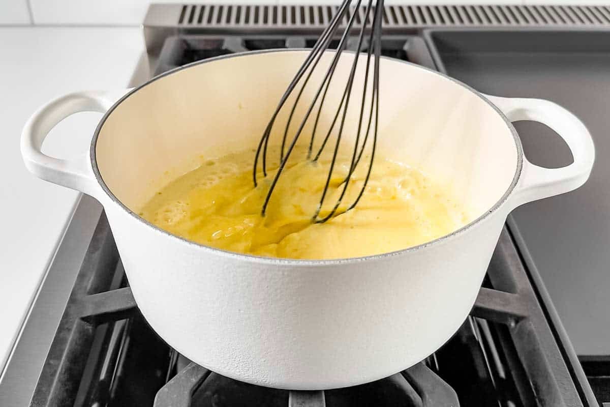 Whisking in the half and half to the egg yolk mixture.