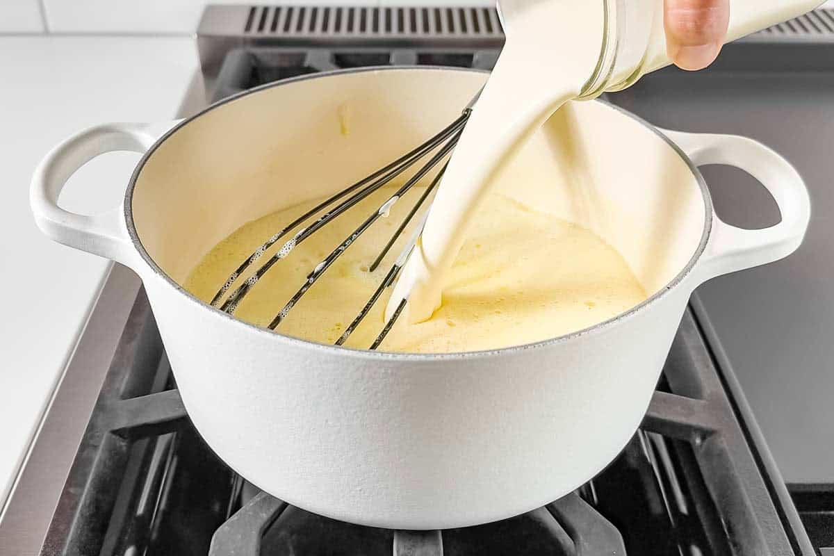 Pouring heavy cream into the cooked ice cream custard.