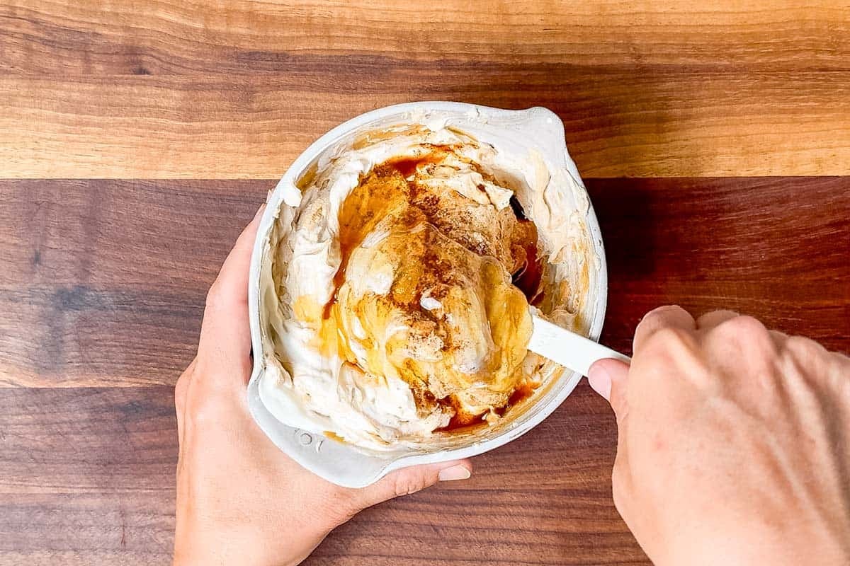 Mixing the honey, cinnamon, and vanilla into the peanut butter mixture.