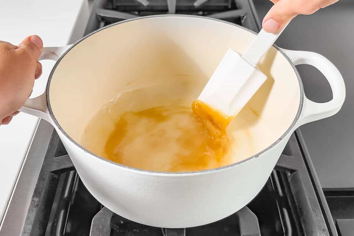 Mixing the cornstarch and maple syrup together in a white pot with a spatula.