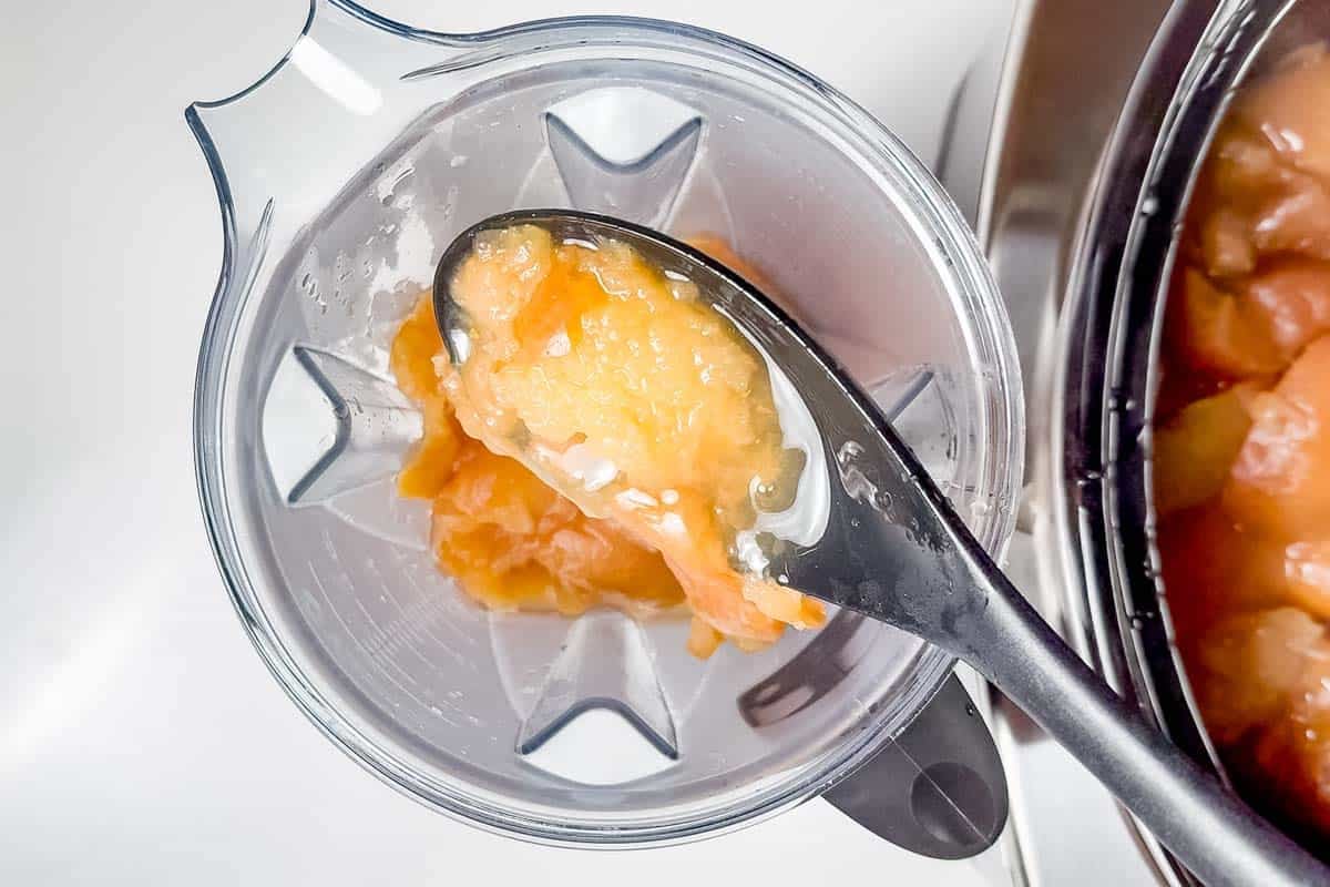 Adding the cooked apples to a blender container.